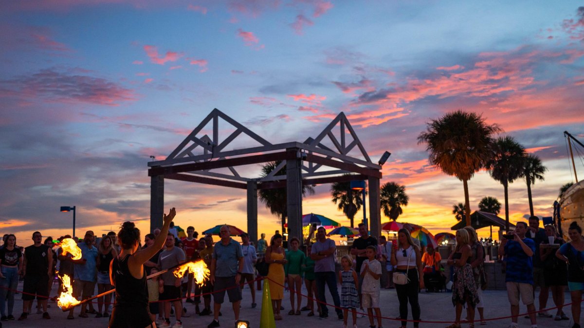 Fire juggler entertains a crowd at sunset