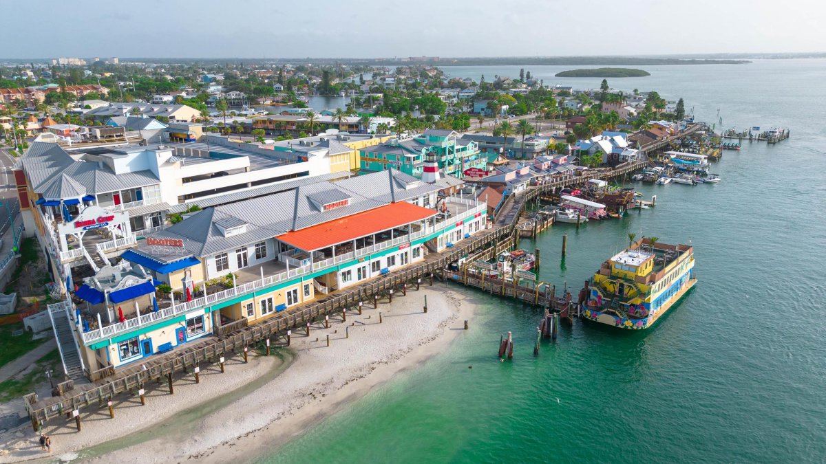 an aerial view of John's Pass Village & Boardwalk, a pier and a large boat