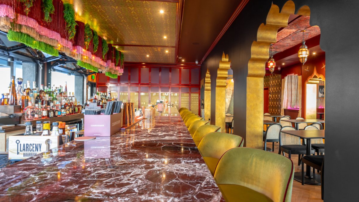 a fancy bar in a restaurant with a blood red granite countertop and chartreuse green chairs